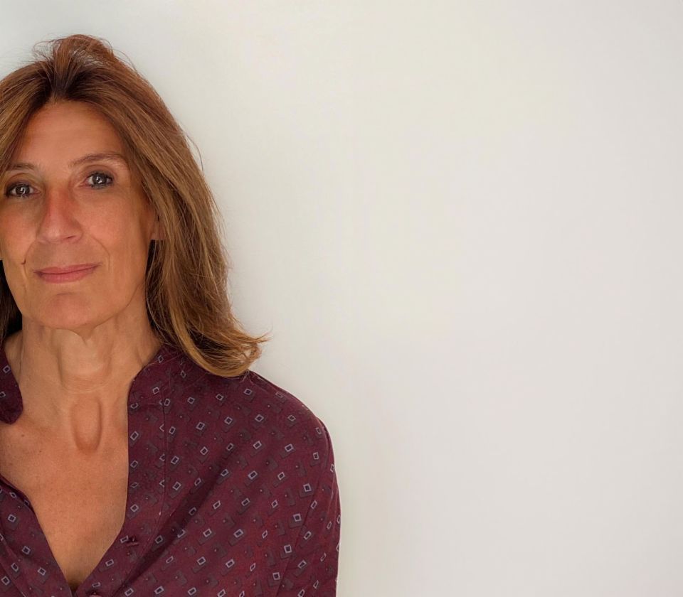Portret Nathalie Lameyre koja stoji u osvijetljenoj sobi