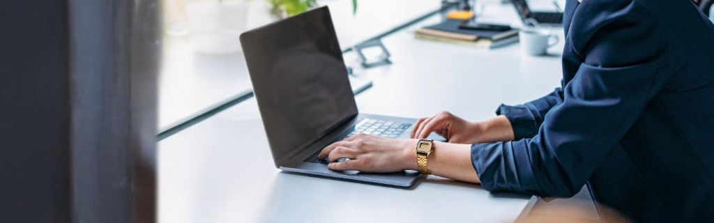Young woman is working on a laptop in a modern office.