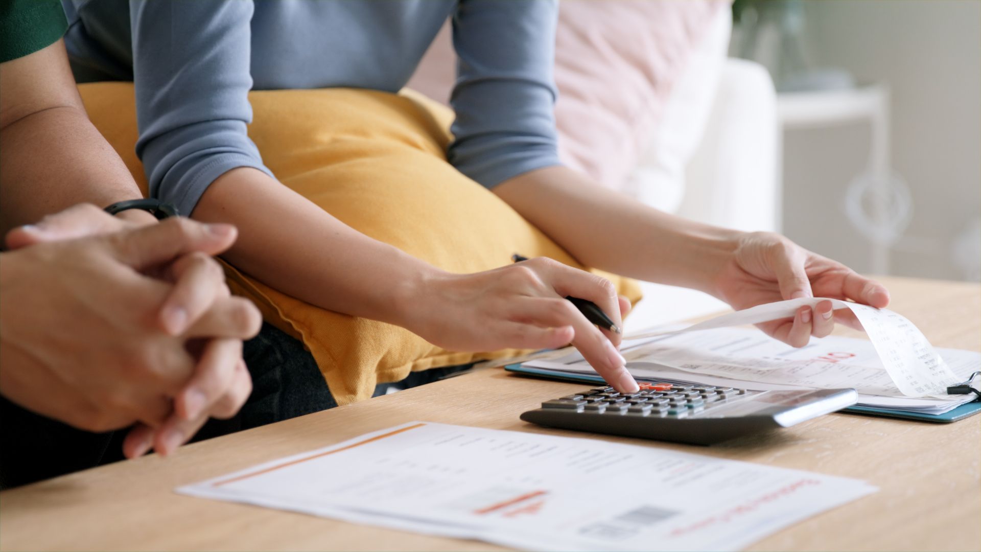 Hands of a woman calculating invoices with a calculator