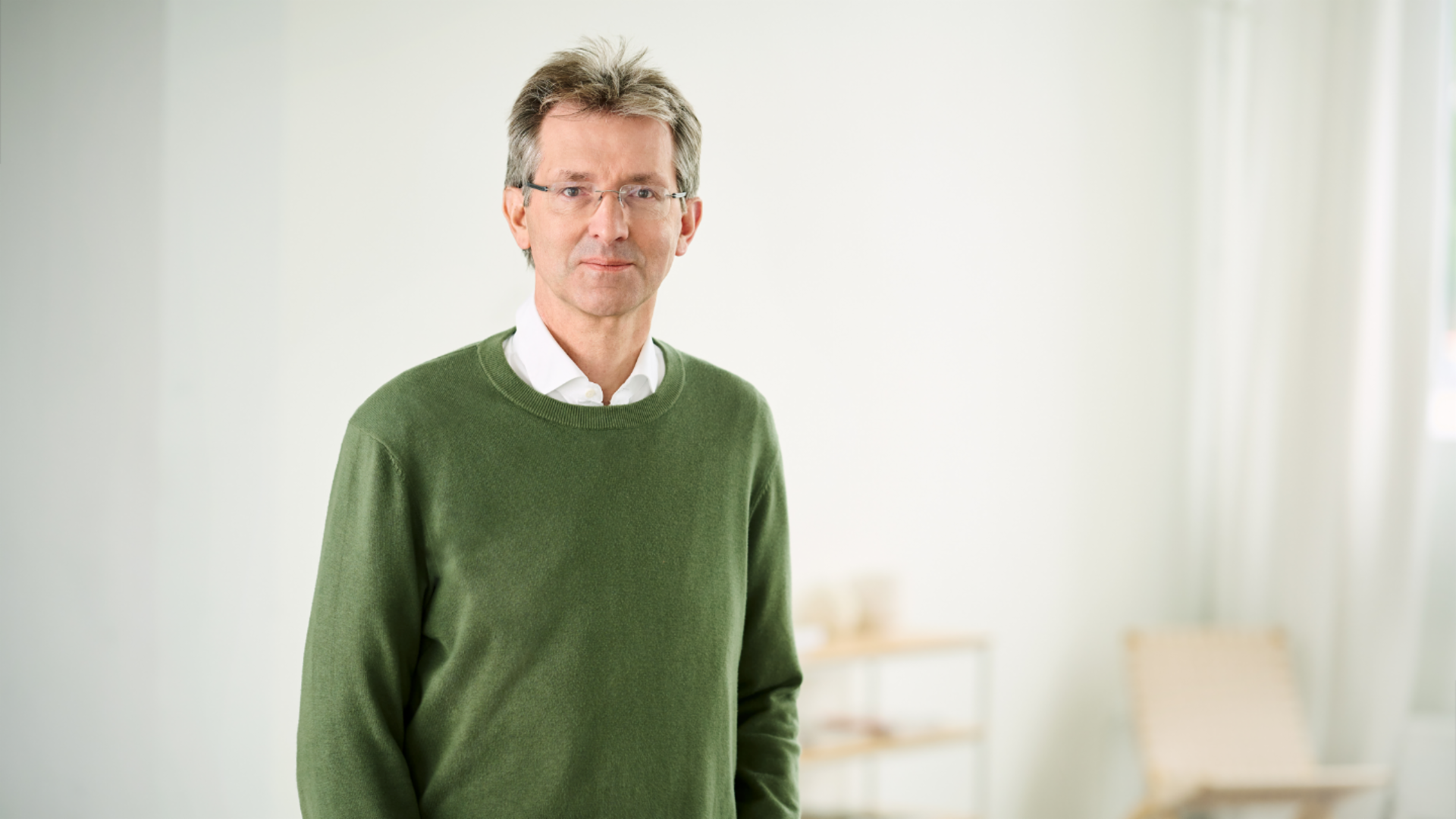 Justus Hecking-Veltman, financijski direktor, odjeven u zeleni džemper i bijelu košulju, stoji u svijetloj sobi.