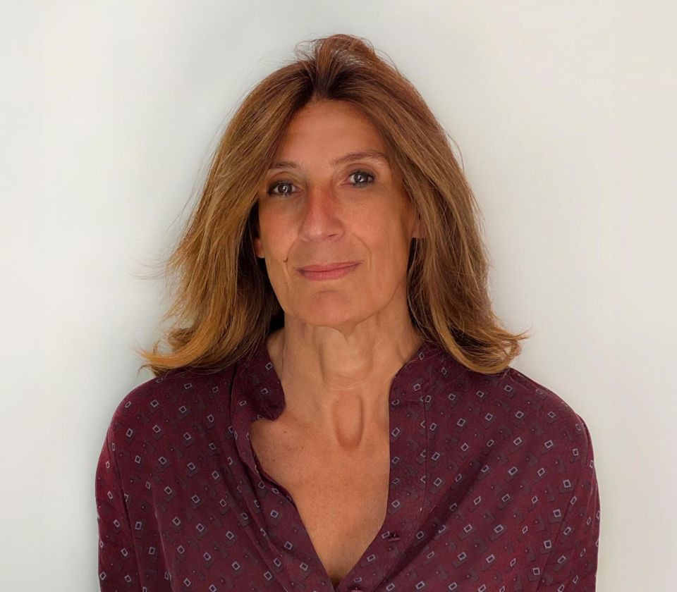 Portret Nathalie Lameyre koja stoji u osvijetljenoj sobi
