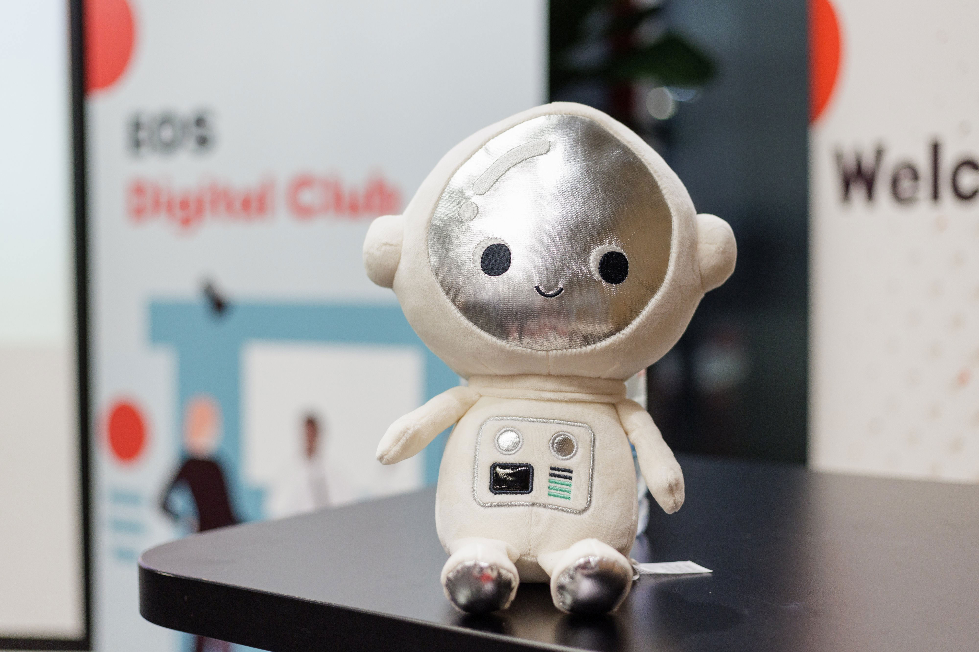 Plišani robot maskota EOS Digital Cluba, simbolizira teme poput umjetne inteligencije i robotike.