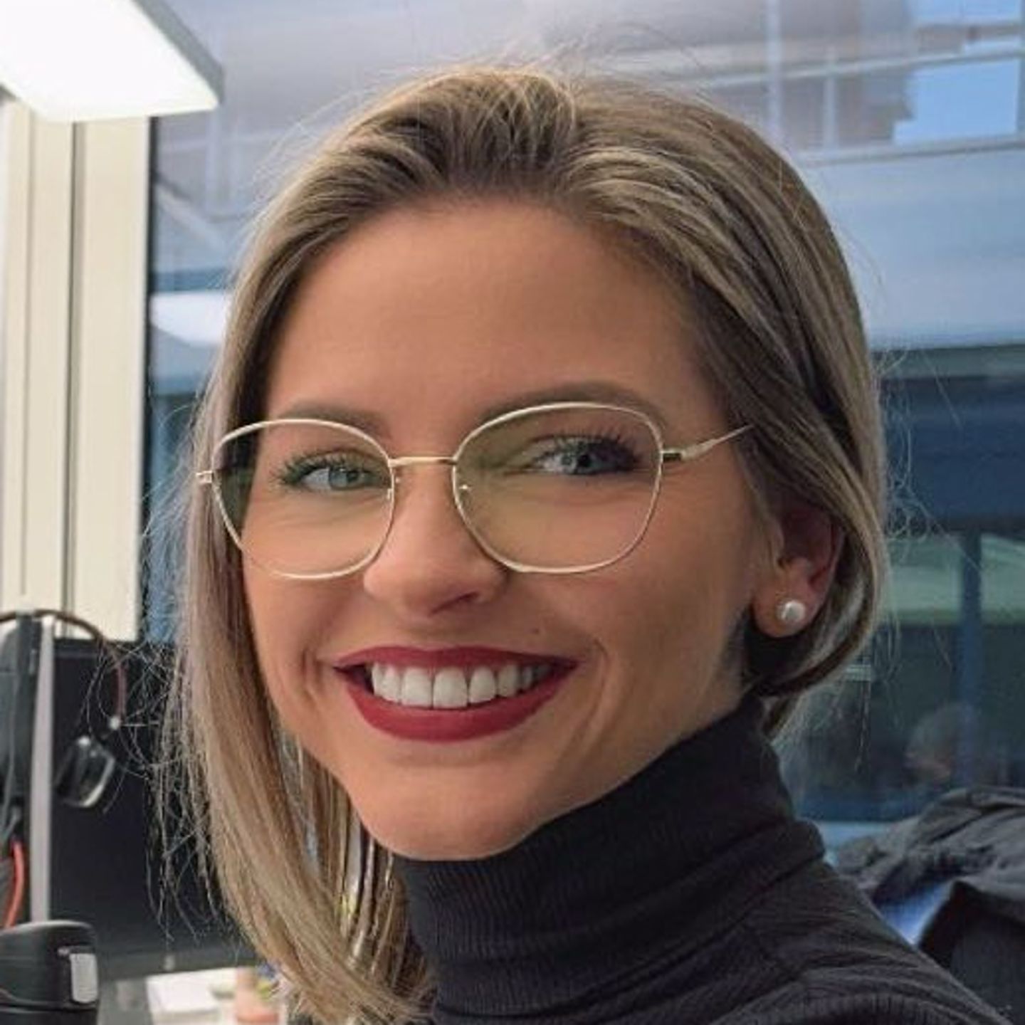 Genny Bollinger, stručnjakinja za restrukturiranje dugova u EOS-u u Švicarskoj, sjedi za svojim stolom u sivom puloveru s dolčevitom i smiješi se u kameru.