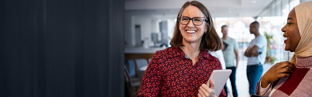 Dvije sretne žene vode ležerni uredski razgovor