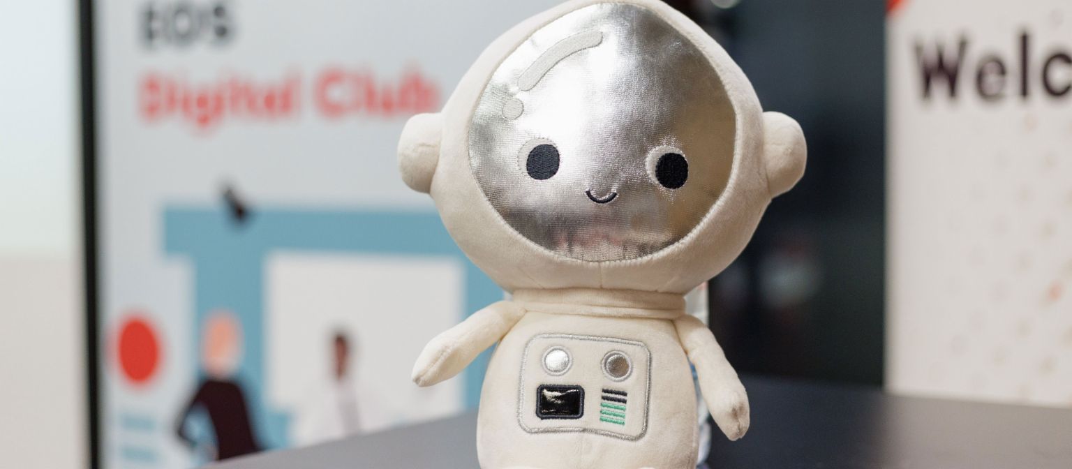 Plišani robot maskota EOS Digital Cluba, simbolizira teme poput umjetne inteligencije i robotike.
