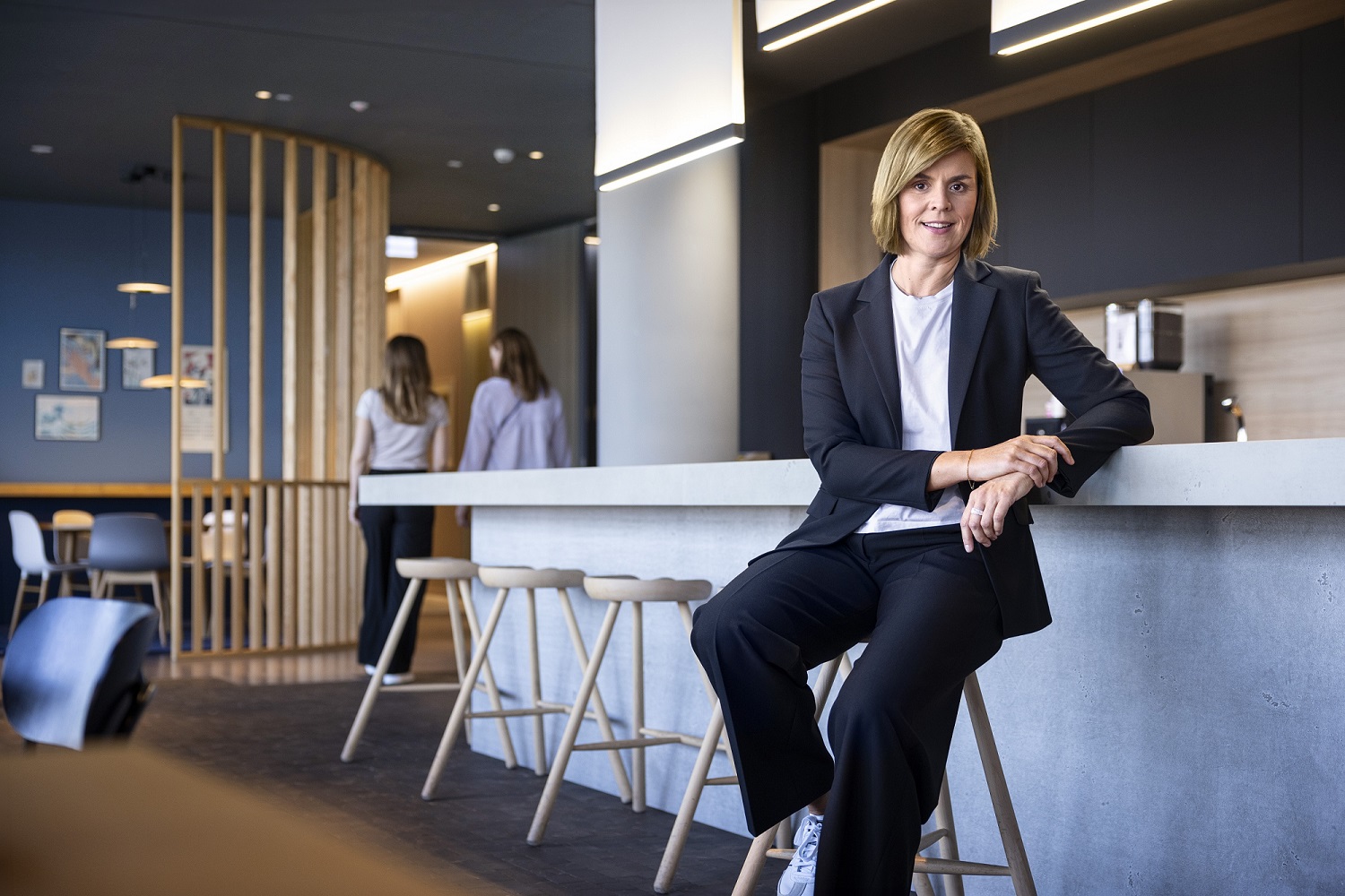 Dr. Eva Griewel, financijska direktorica (CFO) EOS Grupe, sjedi u društvenom prostoru na visokoj stolici, odjevena u crni sako.